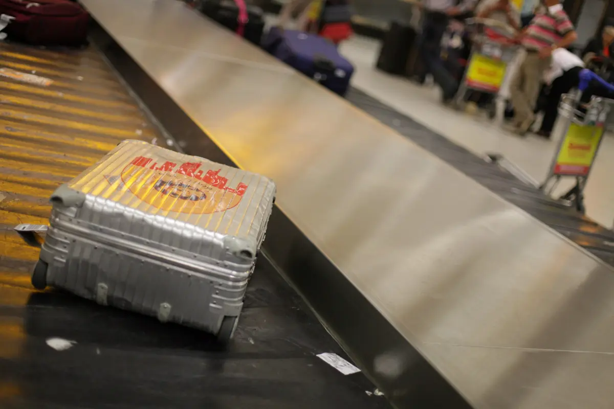 A hard-shell suitcase on an airport baggage carousel